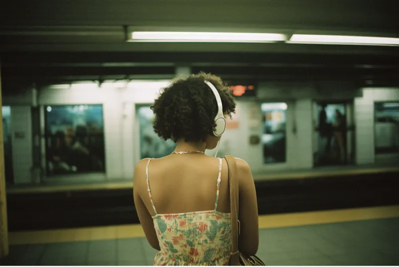 Woman with headphones at subway platform